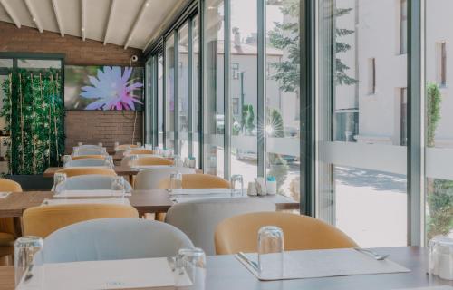 eine Reihe von Tischen und Stühlen in einem Restaurant mit Fenstern in der Unterkunft VE Hotels Adakale in Yenişehir