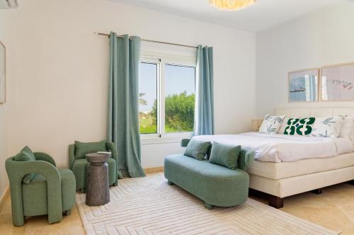 a bedroom with a bed and a chair and a window at VESTA - El Gouna Residence in Hurghada
