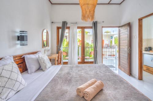 una camera da letto con un letto grande con due asciugamani sopra di Villa iris Homestay a Uluwatu
