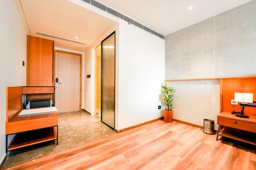 an empty room with wooden floors and a large wall at Nestlay Suites by TC One in Kozhikode