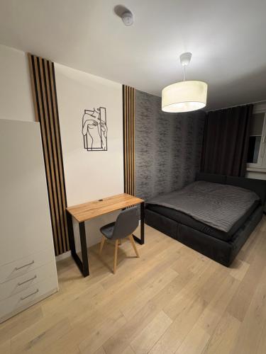 a bedroom with a bed and a desk and a table at Panorama Premium Plac Jana z Głogowa 2 in Głogów