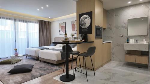 een slaapkamer met een bed en een tafel en een keuken bij CC LUX Suites in Piraeus Port in Piraeus