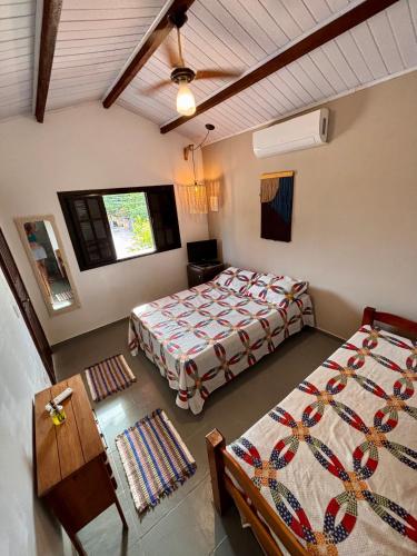 a bedroom with two beds and a table and chairs at Suites e Casa_Pauba in São Sebastião