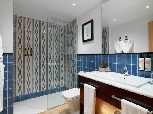 a bathroom with a sink and a toilet and a shower at Boutique Hotel H10 White Suites - Adults Only in Playa Blanca