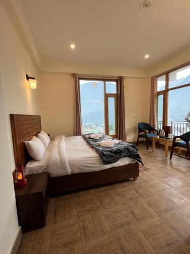 een slaapkamer met een bed met een groot raam bij North Star Homestay Manali in Bashist