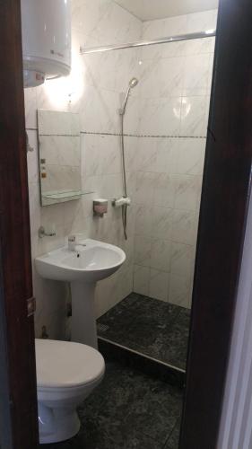a bathroom with a white toilet and a sink at Современная студия-люкс, слобожанській in Samarovka
