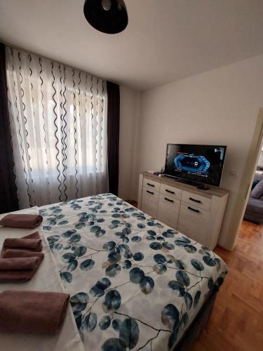 a bedroom with a bed and a flat screen tv at Andrej Apartment with Garage in Bar
