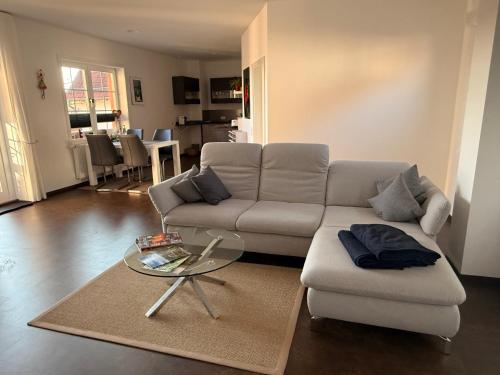 ein Wohnzimmer mit einer Couch und einem Glastisch in der Unterkunft Ferienwohnung Seetalblick in Geiselberg