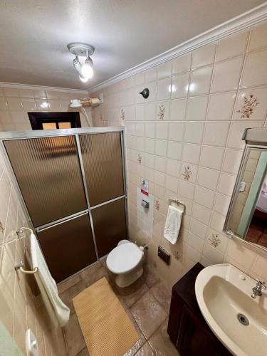 a bathroom with a toilet and a sink at Suites e Casa_Pauba in São Sebastião
