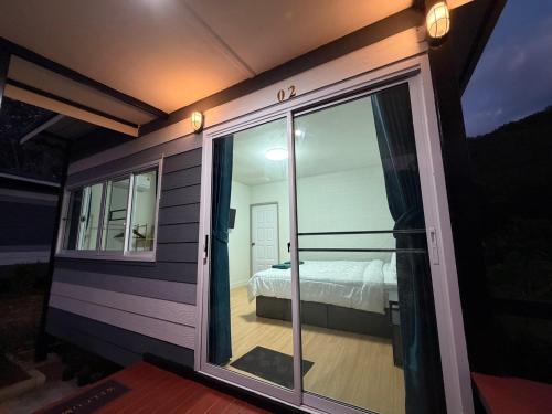 Zimmer mit einem Bett und einer Glasschiebetür in der Unterkunft Greenview Room and Restaurant 