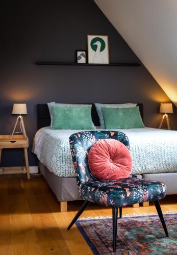 a bedroom with a bed and a chair with a pillow at Complete studio de Stopplaats dichtbij Hoorn en Alkmaar in Zuidermeer