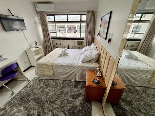 een hotelkamer met twee bedden en een bureau bij Estudio Ao Lado do Parque - 15 mim do Aeroporto. in Brasilia