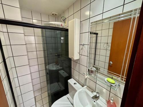 een badkamer met een toilet, een wastafel en een spiegel bij Estudio Ao Lado do Parque - 15 mim do Aeroporto. in Brasilia