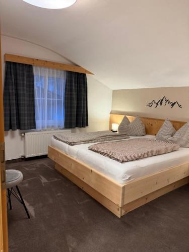 een slaapkamer met een groot bed en een raam bij Appartement Schmid in Oetz