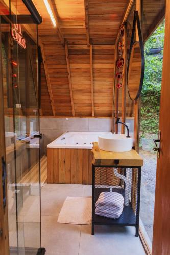 a bathroom with a tub and a sink at CHALÉS SUIÇOS - Românticos na Natureza para adultos - Pernoite das 17h às 11h in Itapecerica da Serra