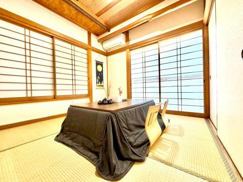 a room with a table in a room with windows at Ninja Tokyo Hideaway Higashi-Shinkoiwa in Tokyo