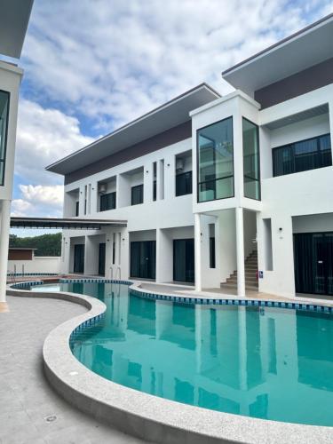 una vista esterna di un edificio con piscina di J&P Hotel Sriracha a Ban Hua Na