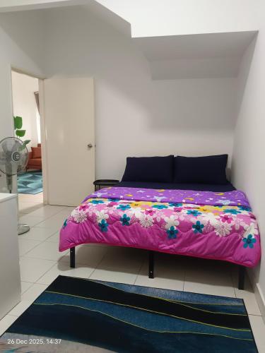 a bedroom with a pink bed with flowers on it at Halia Homestay in Batu Pahat