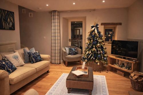 a living room with a christmas tree in it at Kingfisher Cottage at Aysgarth Falls in Aysgarth