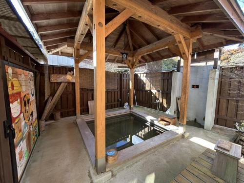 a swimming pool in a building with a wooden ceiling at 民泊の枠を超えた民泊セカンドライフ in Kashima