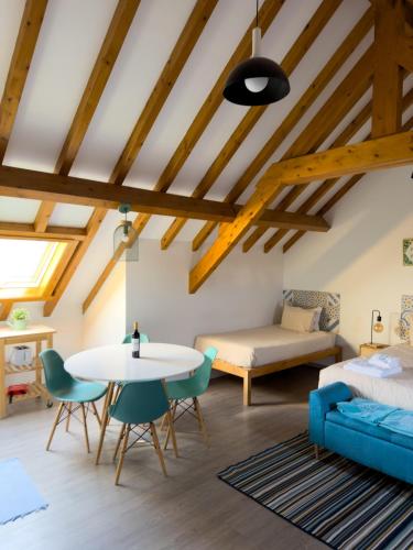 a room with a bed and a table and chairs at GO4SURF beach Lofts in Peniche