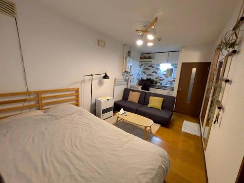 a bedroom with a bed and a couch at SouthHouseS札幌市中心部まで徒歩5分 in Sapporo