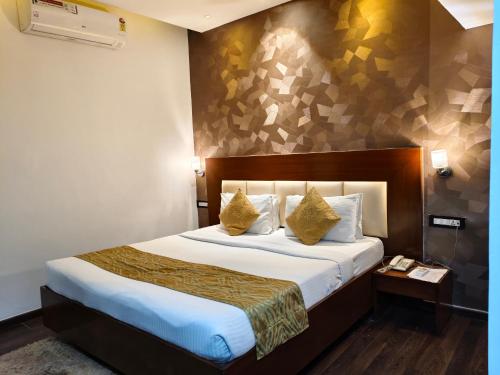 een hotelkamer met een groot bed met gele kussens bij Hemaadri Grand in Hyderabad