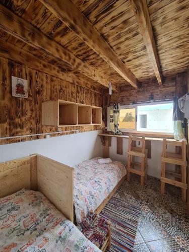 a bedroom with two beds in a room with wooden walls at summer house berber in Tamraght Ouzdar