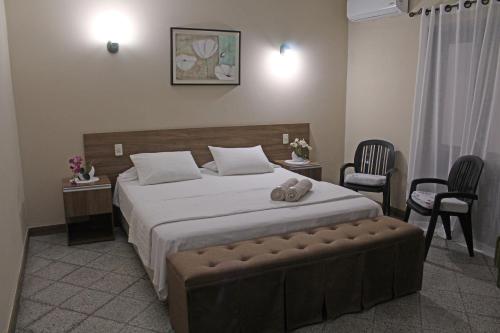 a bedroom with a large bed and two chairs at Das Heim Hotel in Asuncion