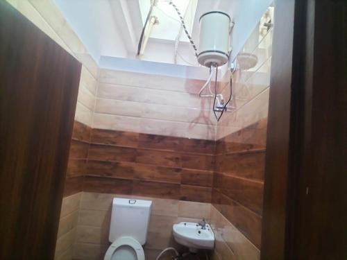 a bathroom with a toilet and a sink at jp hotel and restorent in Rīngas