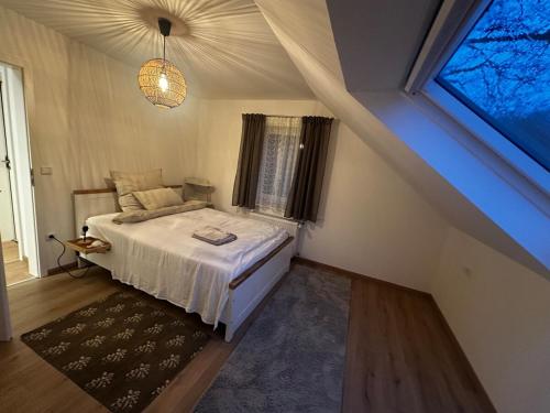 a bedroom with a bed in a room with a window at Waldhaus in Affing