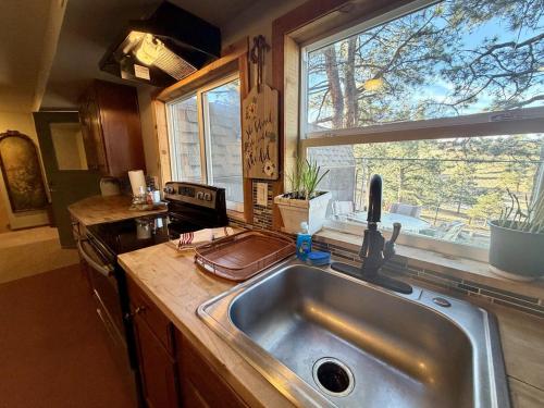 une cuisine avec un évier et une fenêtre dans l'établissement Cozy Rustic Retreat on a Horse Ranch with Stunning Pikes Peak Views and Serenity Minutes from Downtown Woodland Park, à Woodland Park