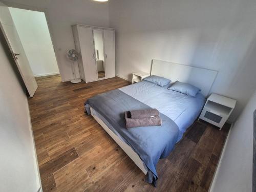 ein Schlafzimmer mit großem Bett und Holzboden in der Unterkunft Flat near Serra da Arrábida, beaches and Lisbon in Quinta do Conde