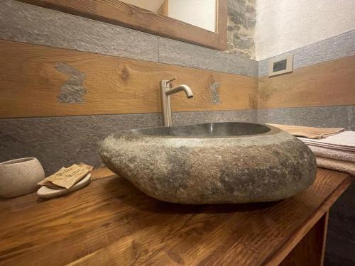 een badkamer met een grote stenen wastafel op een houten aanrecht bij Affittacamere L'Abri in Etroubles