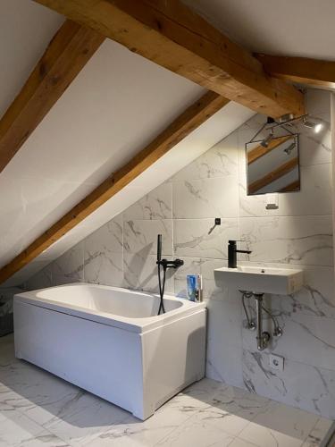 a bathroom with a bath tub and a sink at Vikendica Zeleni san in SJJ