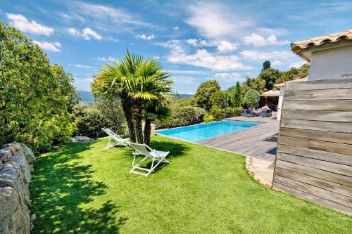 une cour avec deux chaises longues et une piscine dans l'établissement Villa Porto-vecchio 4 chambres avec piscine, à Porto-Vecchio