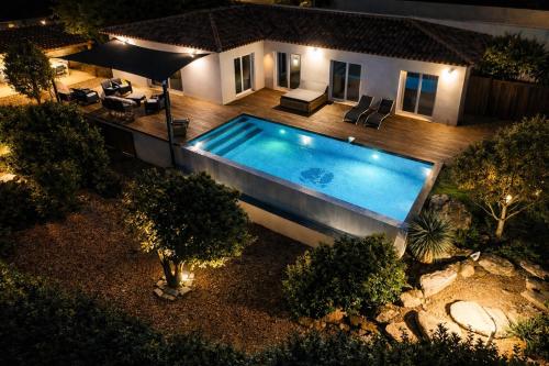 - une vue sur la piscine en face d'une maison dans l'établissement Villa Porto-vecchio 4 chambres avec piscine, à Porto-Vecchio