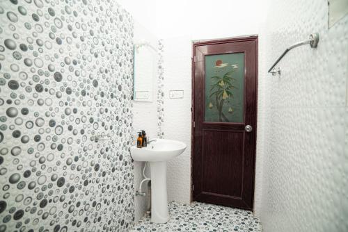 een badkamer met een wastafel, een toilet en een deur bij Villa Prime Time Unawatuna in Unawatuna