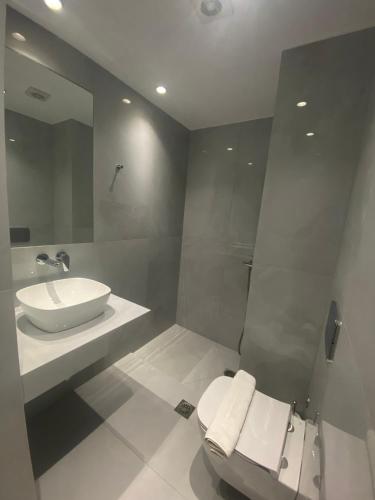 a white bathroom with a sink and a toilet at Panoramic View Boutique Suite in Rethymno