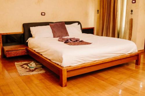 a bed with white sheets and brown clothes on it at Nathay Hotel in Addis Ababa Bole International Airport