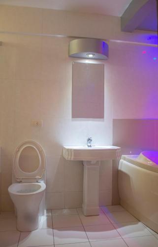 a bathroom with a toilet and a sink at Royal Garden Hotel in Lima