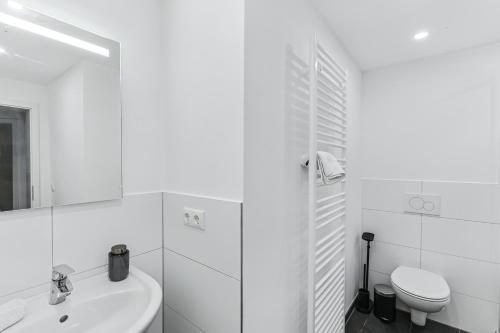 ein weißes Badezimmer mit Waschbecken und Toilette in der Unterkunft ARCHIPEL-Nahe Hamburg-Terasse-Neu in Geesthacht