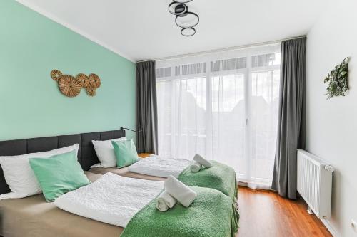 ein Schlafzimmer mit 2 Betten und einem grünen Sofa in der Unterkunft ARCHIPEL-Nahe Hamburg-Terasse-Neu in Geesthacht