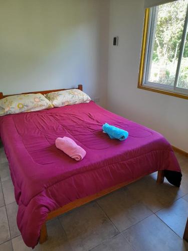 a bed with two pillows and two towels on it at Casita Rosa II in San José