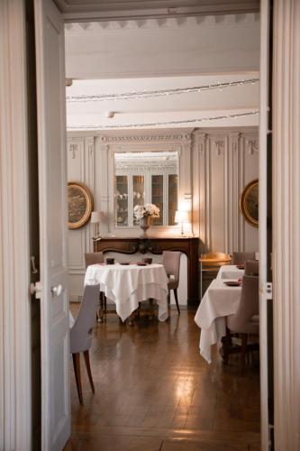 a dining room with a table and a piano at Château Hôtel, Restaurant & Spa De La Commanderie in Eybens
