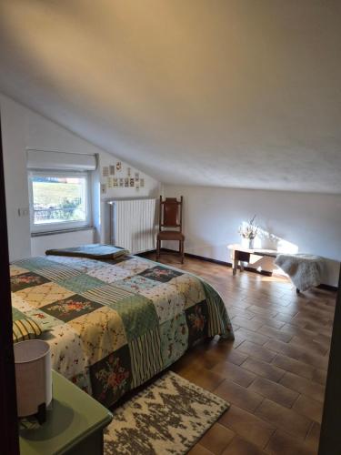 una camera da letto con un letto, un tavolo e una finestra di Orion House ad Ardenno