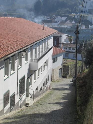 a white building with a red roof on a street at Lavanda Termas de São Pedro do Sul in Termas de Sao Pedro do Sul