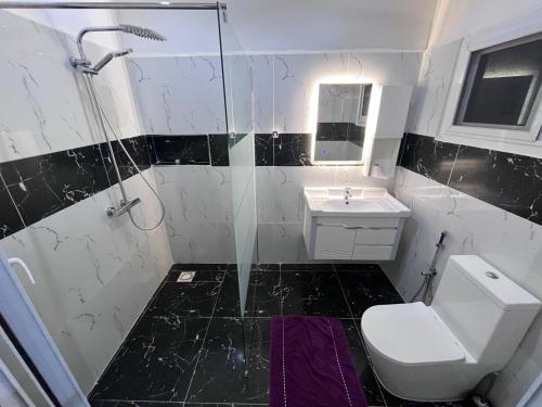 een badkamer met een douche, een toilet en een wastafel bij Terranga in Mbour