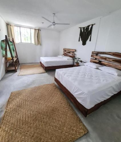 ein Schlafzimmer mit zwei Betten und zwei Teppichen in der Unterkunft Tropic Bacalar in Bacalar