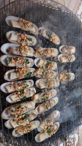 a bunch of oysters are cooking on a grill at Homestay Hải Nam Đất Mũi in Xóm Mũi